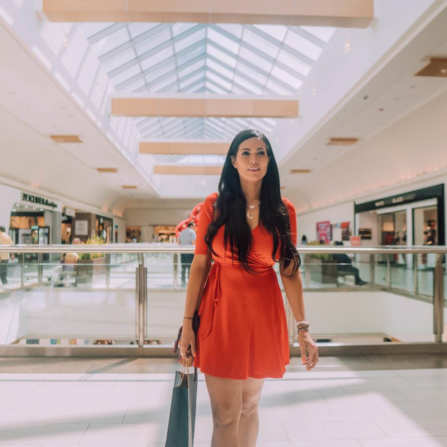 A woman walks through the mall with a bag in her hand