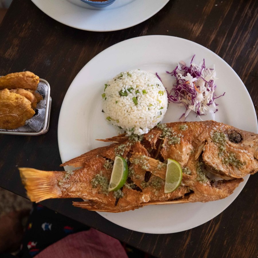 Un plato salado con pescado frito y arroz blanco.