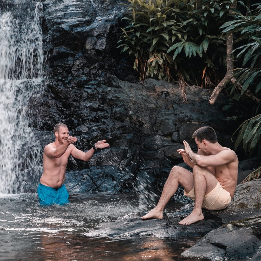 A couple enjoys the day under a waterfall