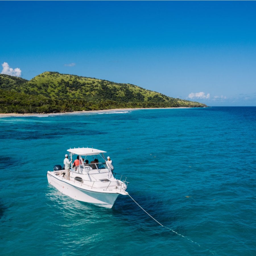 A boat is anchored off a beautiful beach in Puerto Rico