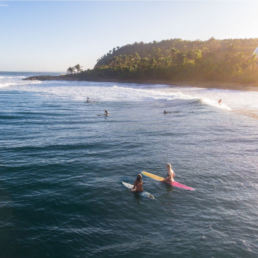 Los surfistas reman para atrapar una ola en Domes Beach en Rincón, Puerto Rico.