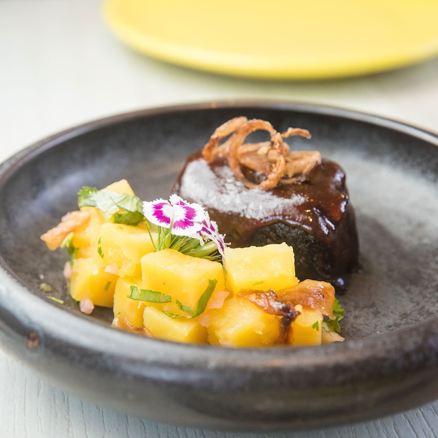 Chef Mario Pagan's Guava BBQ Short Rib sits on a charcoal gray plate.