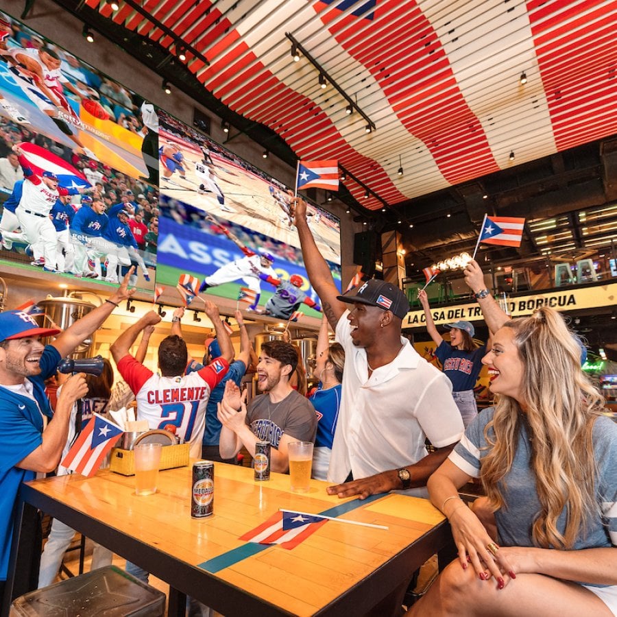 A group celebrates Puerto Rico's baseball team at the Arena Medalla lounge in Distrito T-Mobile