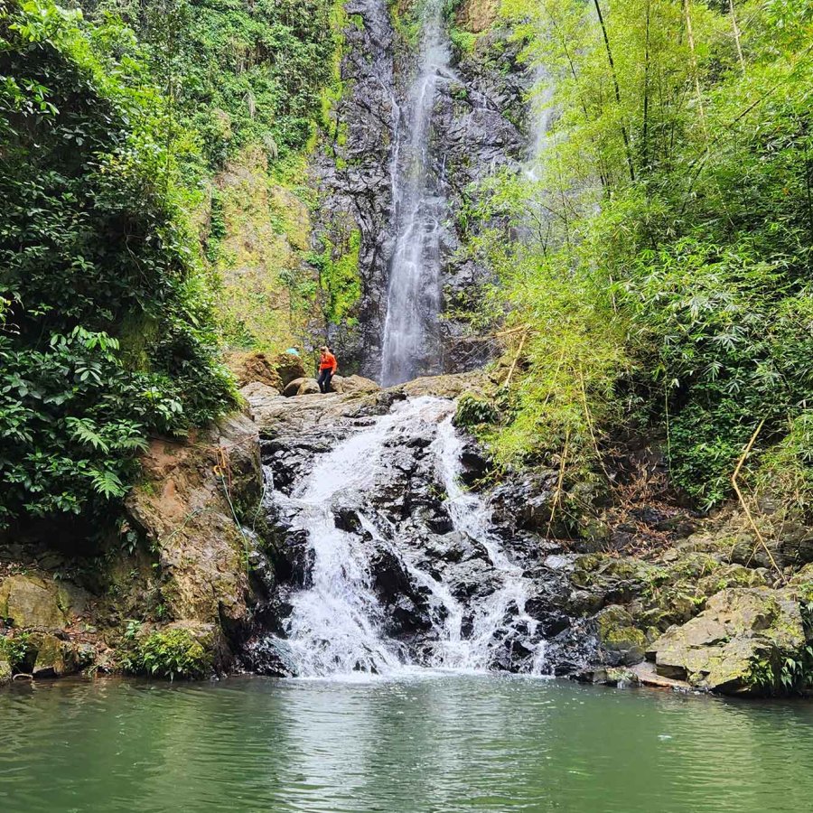 People stand above Chaco Prieto waterfall on a tour by Castillo Tours, Puerto Rico.