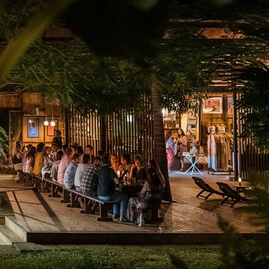 A group shares dinner over candlelight at a long table at Finca Victoria in Vieques, Puerto Rico.