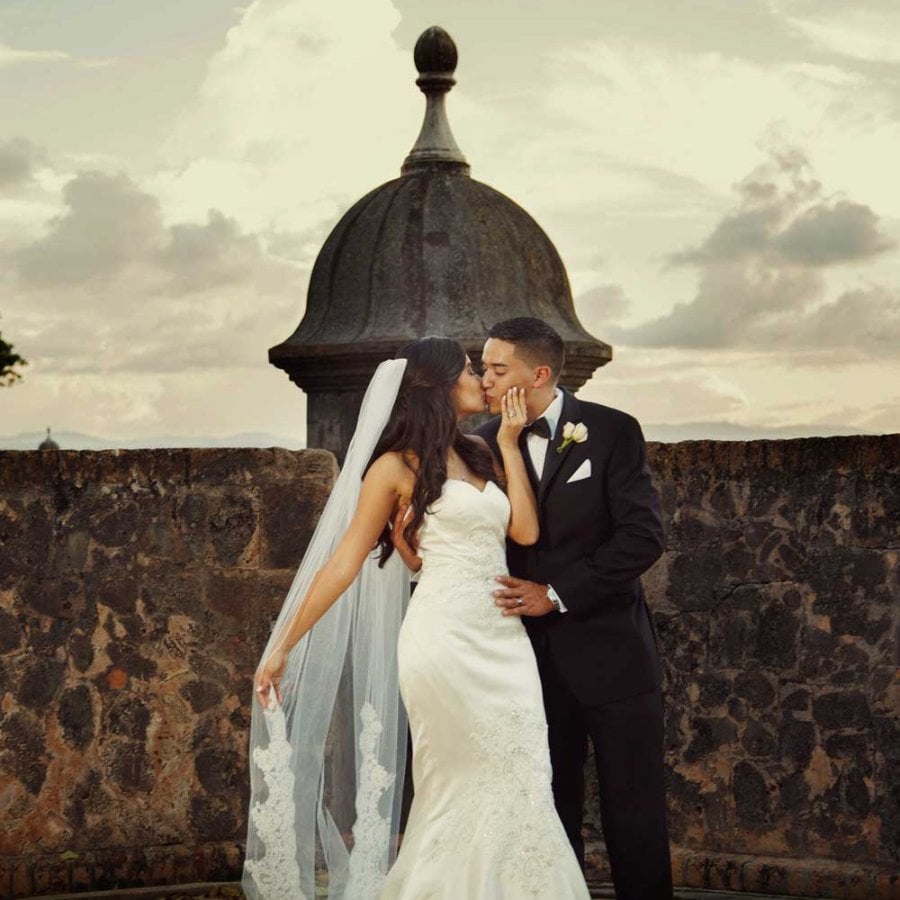 Una novia y un novio se besan frente a una histórica garita en el Viejo San Juan. Foto de Noel Del Pilar.