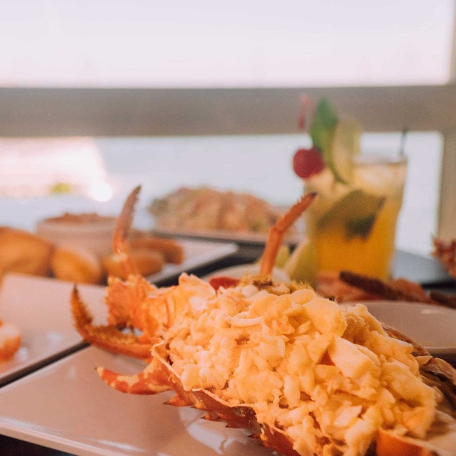 Two plates of fresh lobster sit on a table with a water view at El Dorado restaurant in Salinas, Puerto Rico.