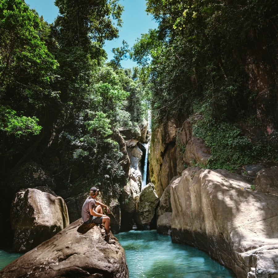 Hombre frente a la cascada.